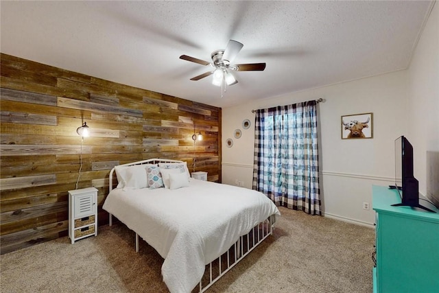 carpeted bedroom featuring a ceiling fan, a textured ceiling, and wooden walls