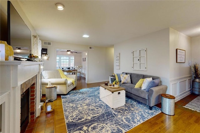 living room featuring a fireplace, wood finished floors, and visible vents