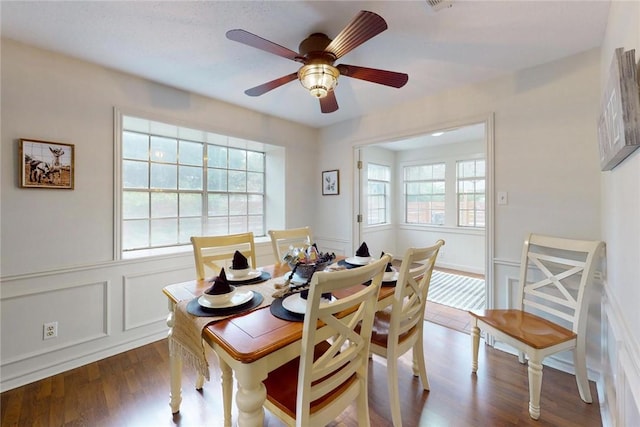 dining space with ceiling fan and dark wood-style floors