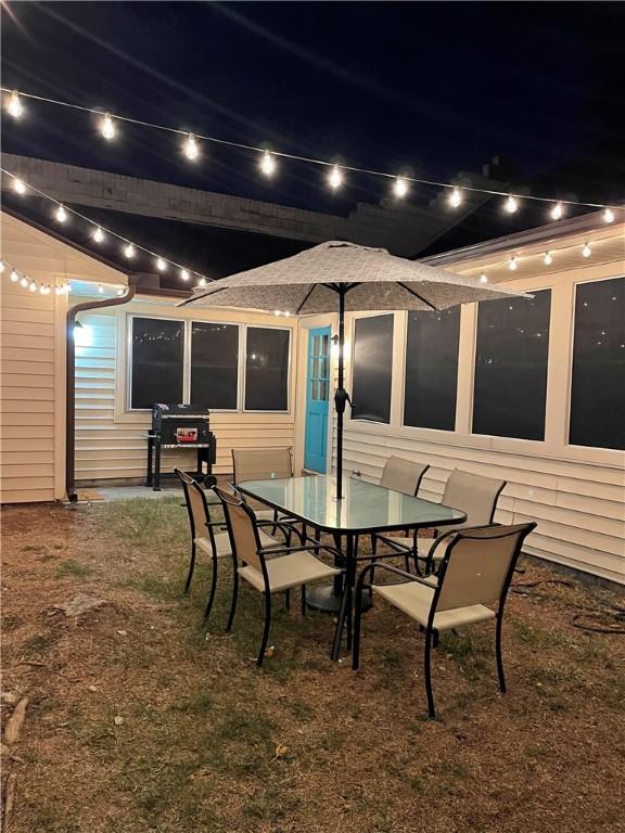 patio at night featuring outdoor dining space