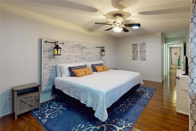 bedroom featuring baseboards, dark wood finished floors, and ceiling fan