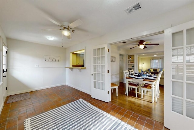spare room with baseboards, a ceiling fan, tile patterned floors, and visible vents