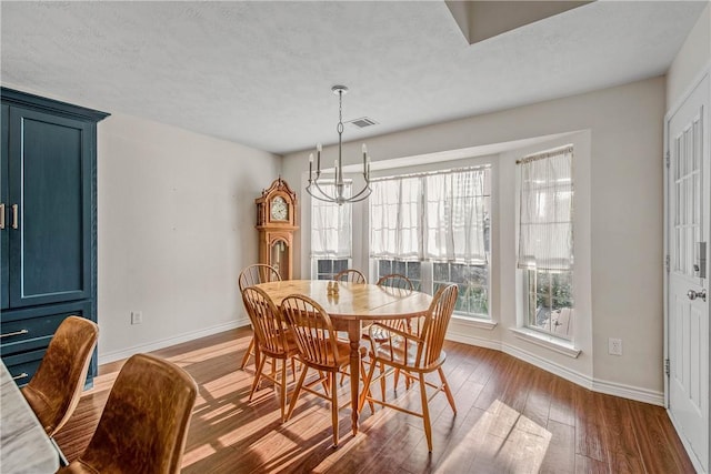 dining area featuring a notable chandelier and dark wood-type flooring