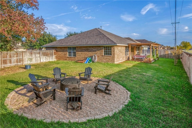 rear view of property with a yard, a deck, and an outdoor fire pit