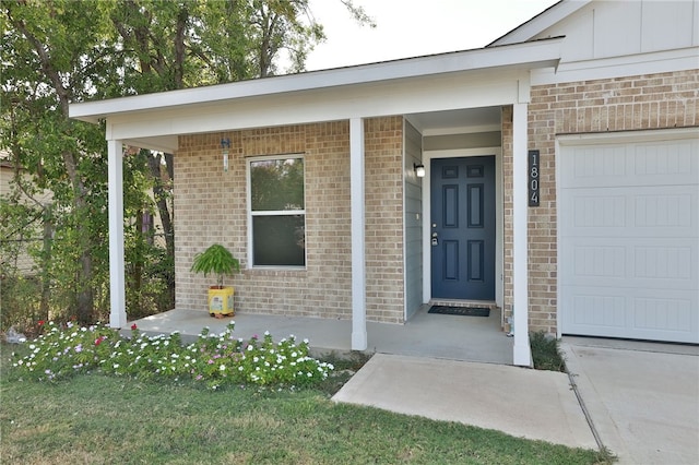 property entrance with covered porch and a garage