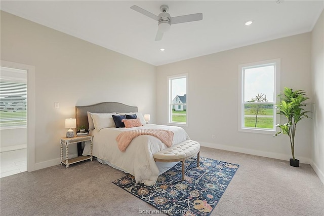 carpeted bedroom featuring multiple windows and ceiling fan