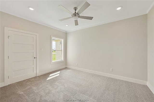 empty room featuring carpet flooring, ceiling fan, and crown molding