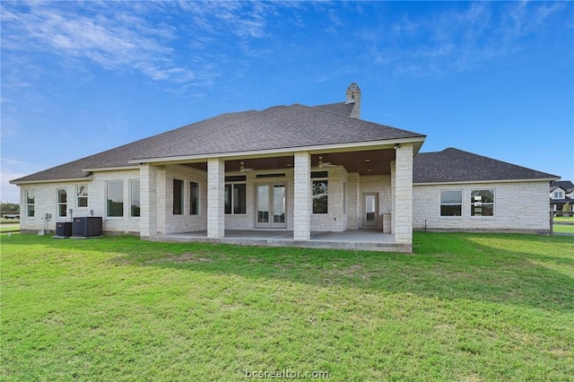 rear view of house featuring ceiling fan, a yard, and a patio