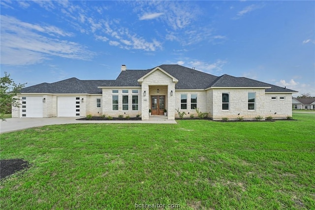 view of front of home with a front yard and a garage