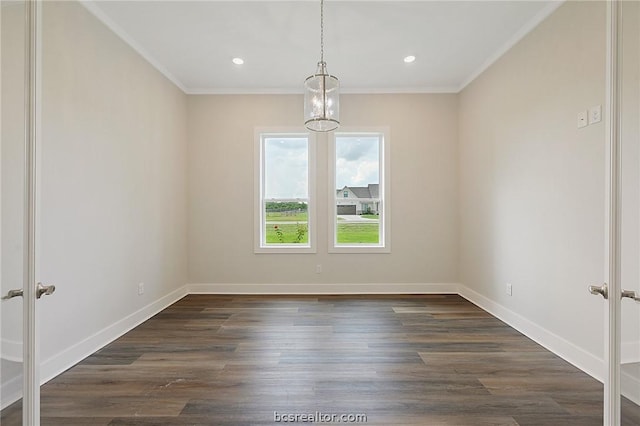 unfurnished room featuring dark hardwood / wood-style flooring, ornamental molding, and a chandelier