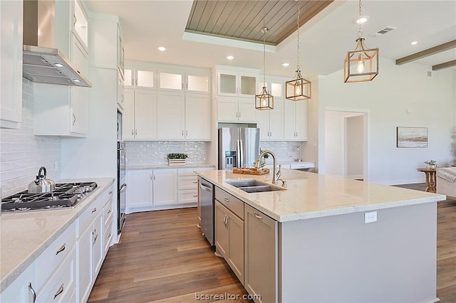 kitchen with dark wood-type flooring, sink, wall chimney exhaust hood, appliances with stainless steel finishes, and white cabinetry