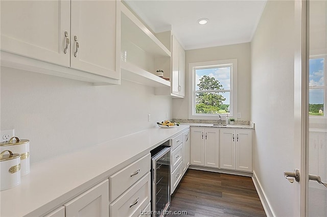 kitchen with dark hardwood / wood-style flooring, white cabinetry, sink, and beverage cooler