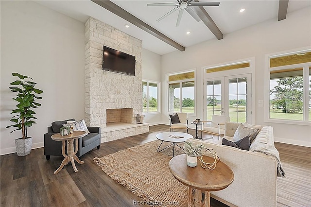 living room with ceiling fan, french doors, dark wood-type flooring, beamed ceiling, and a fireplace