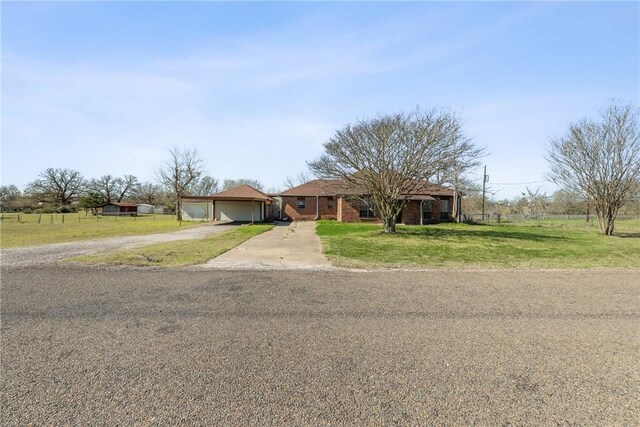 view of front of home with brick siding, an attached garage, concrete driveway, and a front yard