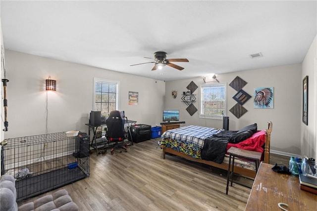 bedroom featuring multiple windows, wood finished floors, and visible vents