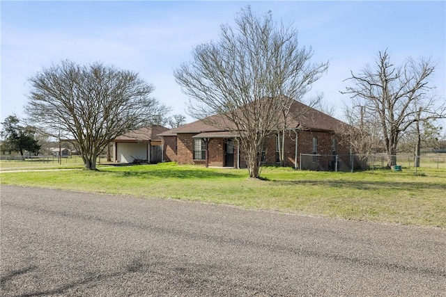 ranch-style home with brick siding, an attached garage, a front yard, and fence