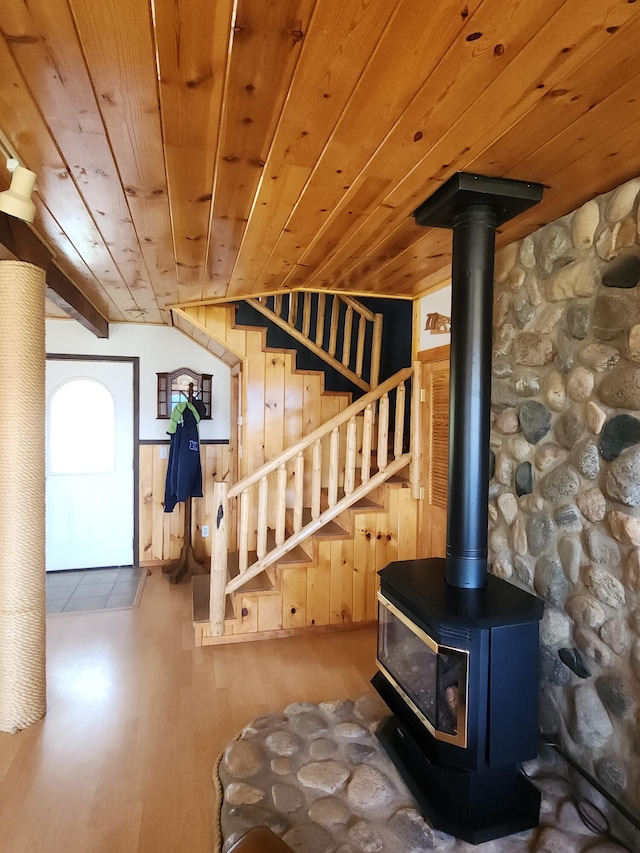 interior space featuring a wood stove, wood ceiling, stairs, and wood finished floors