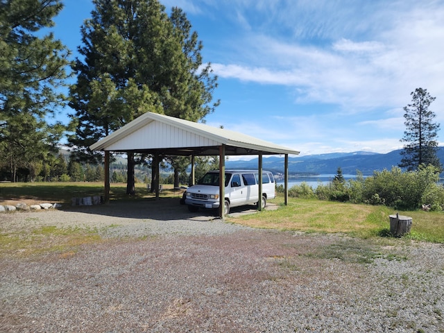 view of parking / parking lot featuring a carport, driveway, and a mountain view