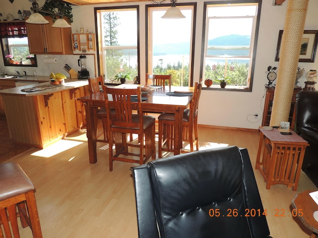 dining area featuring light wood-style flooring and baseboards