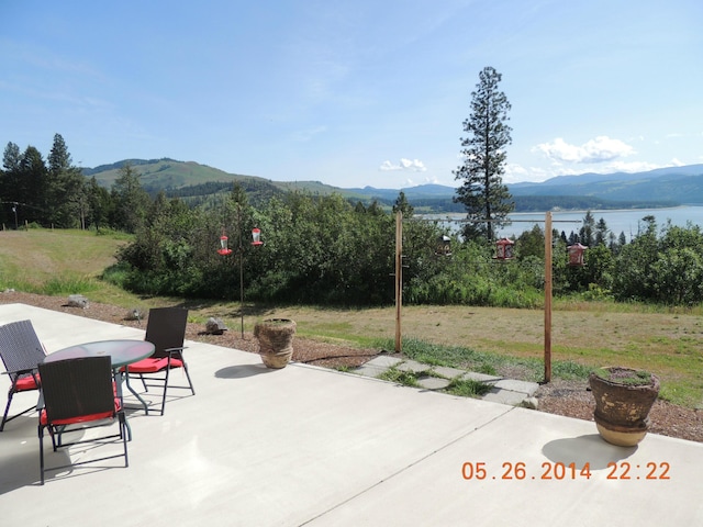 view of patio / terrace with a water and mountain view