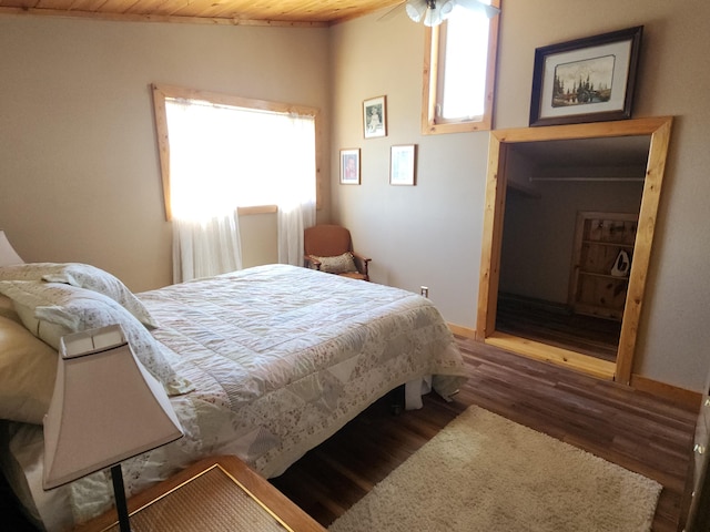 bedroom with baseboards, vaulted ceiling, and dark wood-style flooring