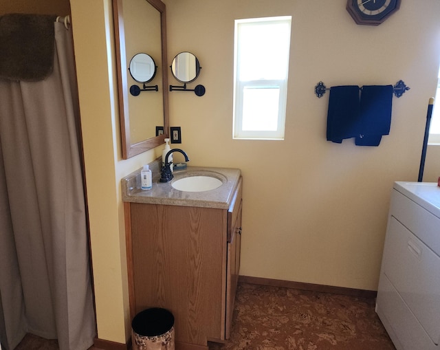 bathroom with washer / dryer, baseboards, and vanity