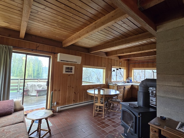 interior space featuring baseboard heating, a wood stove, dark tile patterned flooring, beamed ceiling, and an AC wall unit