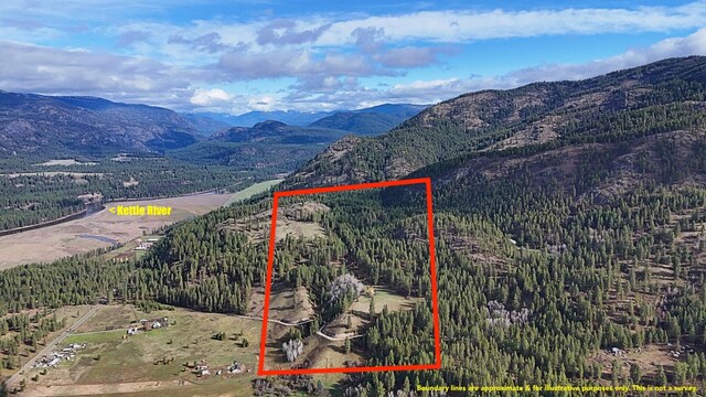 3434 Rockcut Rd, Kettle Falls, WA 99141 - aerial view of property's location featuring a forest, a mountainous background, and property boundaries highlighted