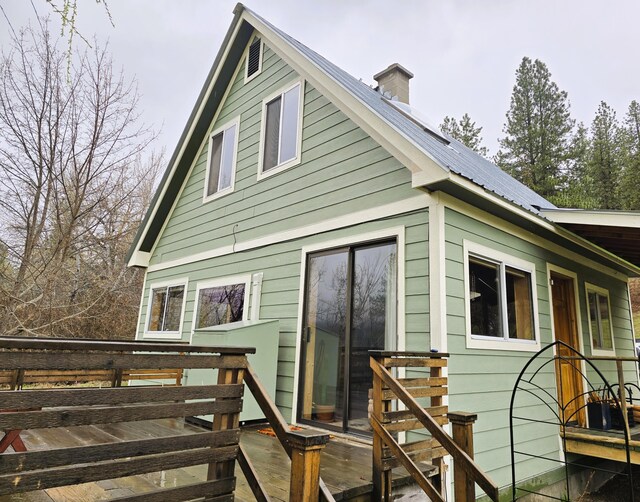 3434 Rockcut Rd, Kettle Falls, WA 99141 - back of house featuring a deck, a chimney, metal roof, and solar panels