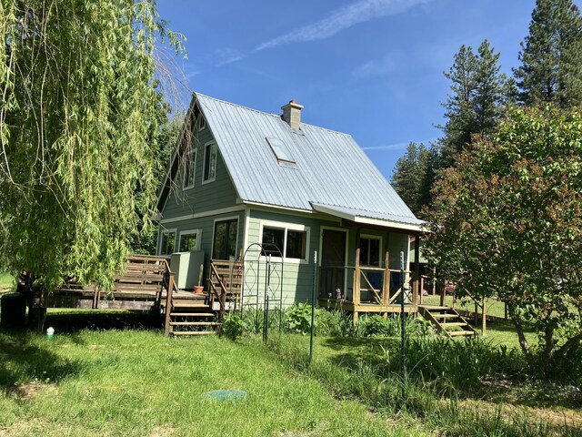 3434 Rockcut Rd, Kettle Falls, WA 99141 - back of house featuring metal roof, a chimney, and a wooden deck