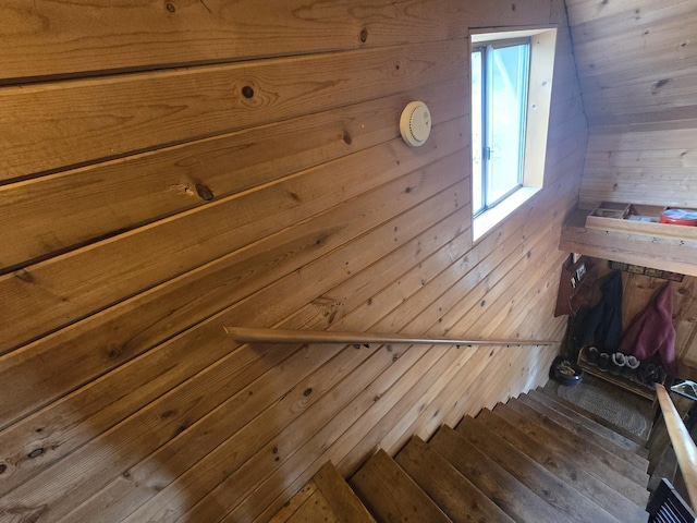 stairway featuring wood walls