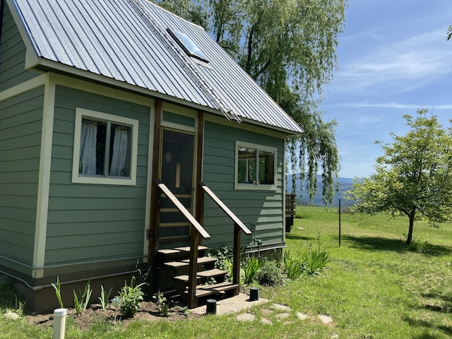 3434 Rockcut Rd, Kettle Falls, WA 99141 - rear view of house featuring entry steps, a yard, metal roof, and a mountain view
