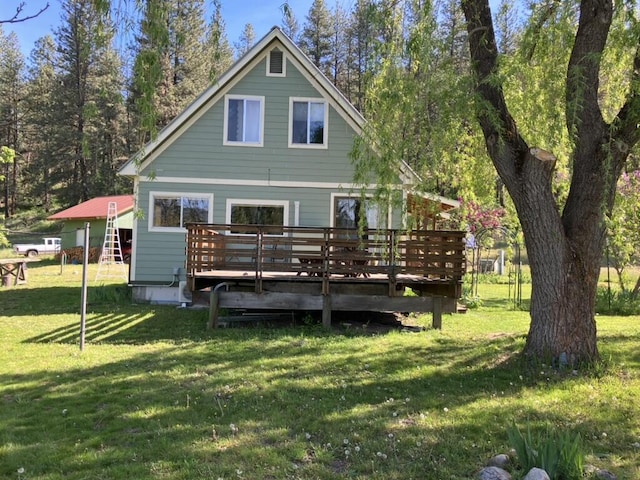 rear view of house featuring a yard and a deck