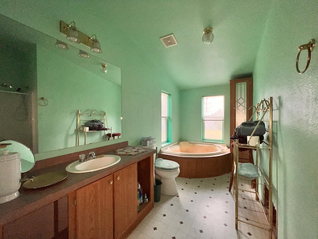 bathroom with a bathtub, vanity, toilet, and vaulted ceiling