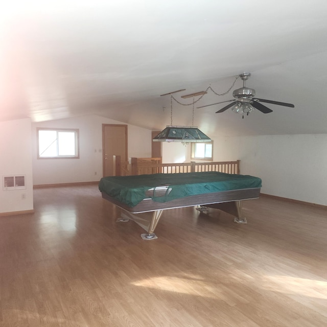 recreation room with lofted ceiling, a ceiling fan, baseboards, visible vents, and wood finished floors