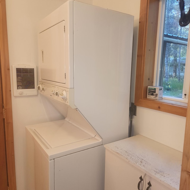 washroom with laundry area and stacked washer / drying machine