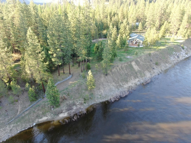 bird's eye view featuring a wooded view and a water view