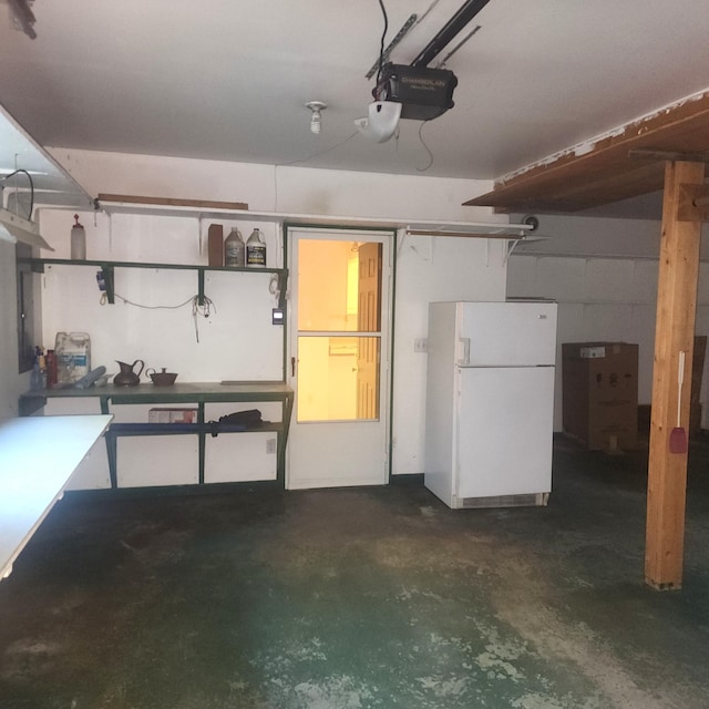 garage featuring freestanding refrigerator and a garage door opener