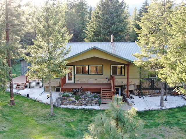 view of front of house with a deck, metal roof, a front lawn, stairway, and a patio area
