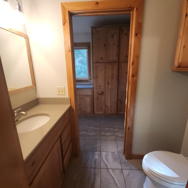 bathroom with vanity, toilet, and marble finish floor