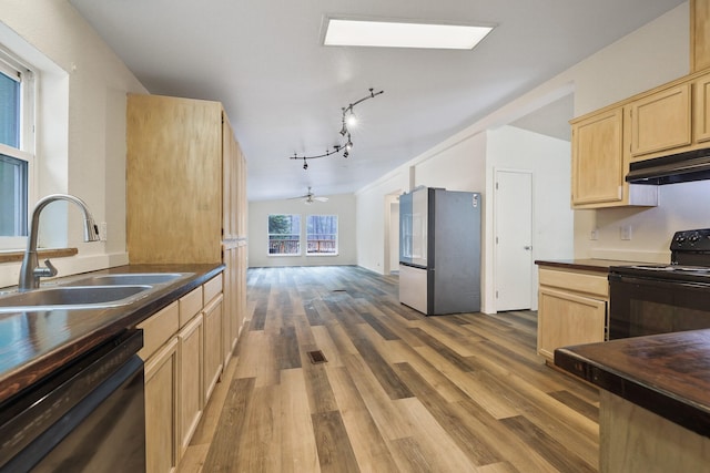 4087 Hesseltine Rd, Valley, WA 99181 - kitchen with wood finished floors, light brown cabinets, under cabinet range hood, a sink, and black appliances