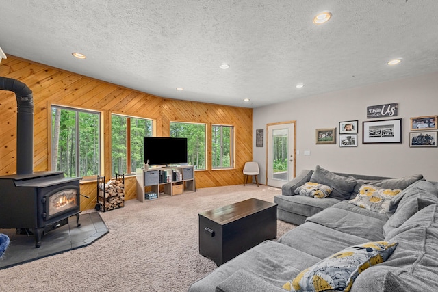 1157 Orin-Rice Rd, Colville, WA 99114 - living room with recessed lighting, wooden walls, a wood stove, carpet floors, and a textured ceiling