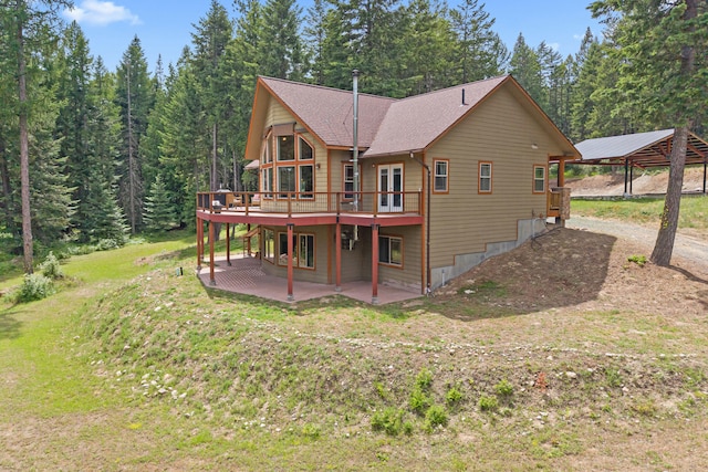 1157 Orin-Rice Rd, Colville, WA 99114 - back of house featuring a wooden deck, a yard, a patio area, a carport, and a shingled roof