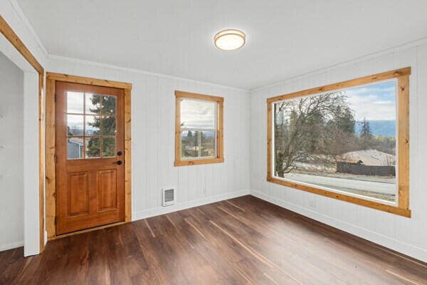 foyer with dark wood-type flooring and ornamental molding