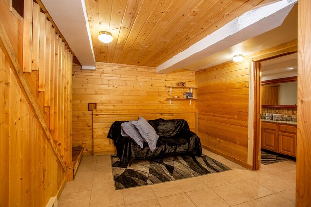 sitting room featuring wood walls, wooden ceiling, and light tile patterned flooring