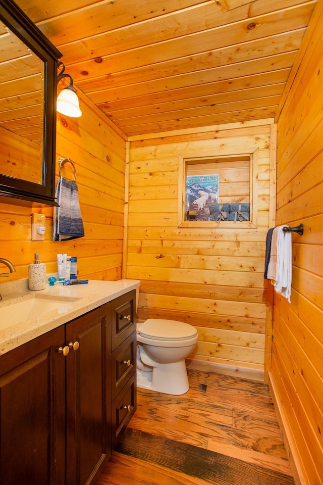 bathroom featuring toilet, wooden ceiling, wood-type flooring, vanity, and wood walls