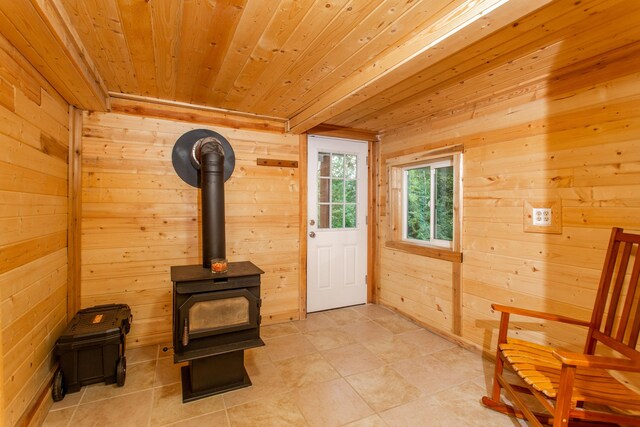 sitting room featuring wood walls, a wood stove, and wood ceiling