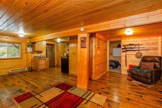 living room featuring a baseboard radiator, hardwood / wood-style floors, wood ceiling, and wooden walls