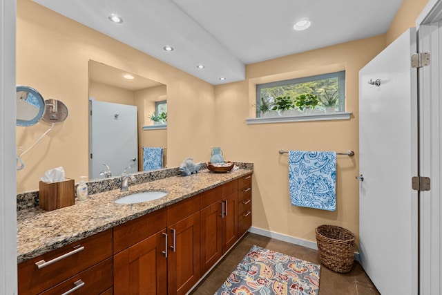 bathroom featuring tile patterned flooring, baseboards, vanity, and recessed lighting