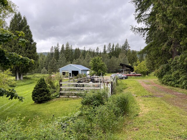 3901 Cedar Creek Rd, Colville, WA 99114 - view of yard featuring a forest view, driveway, an outbuilding, and an outdoor structure
